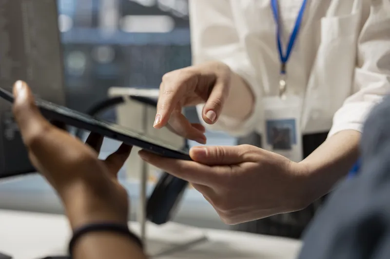 Two colleagues reviewing application metrics on a tablet inside a data center